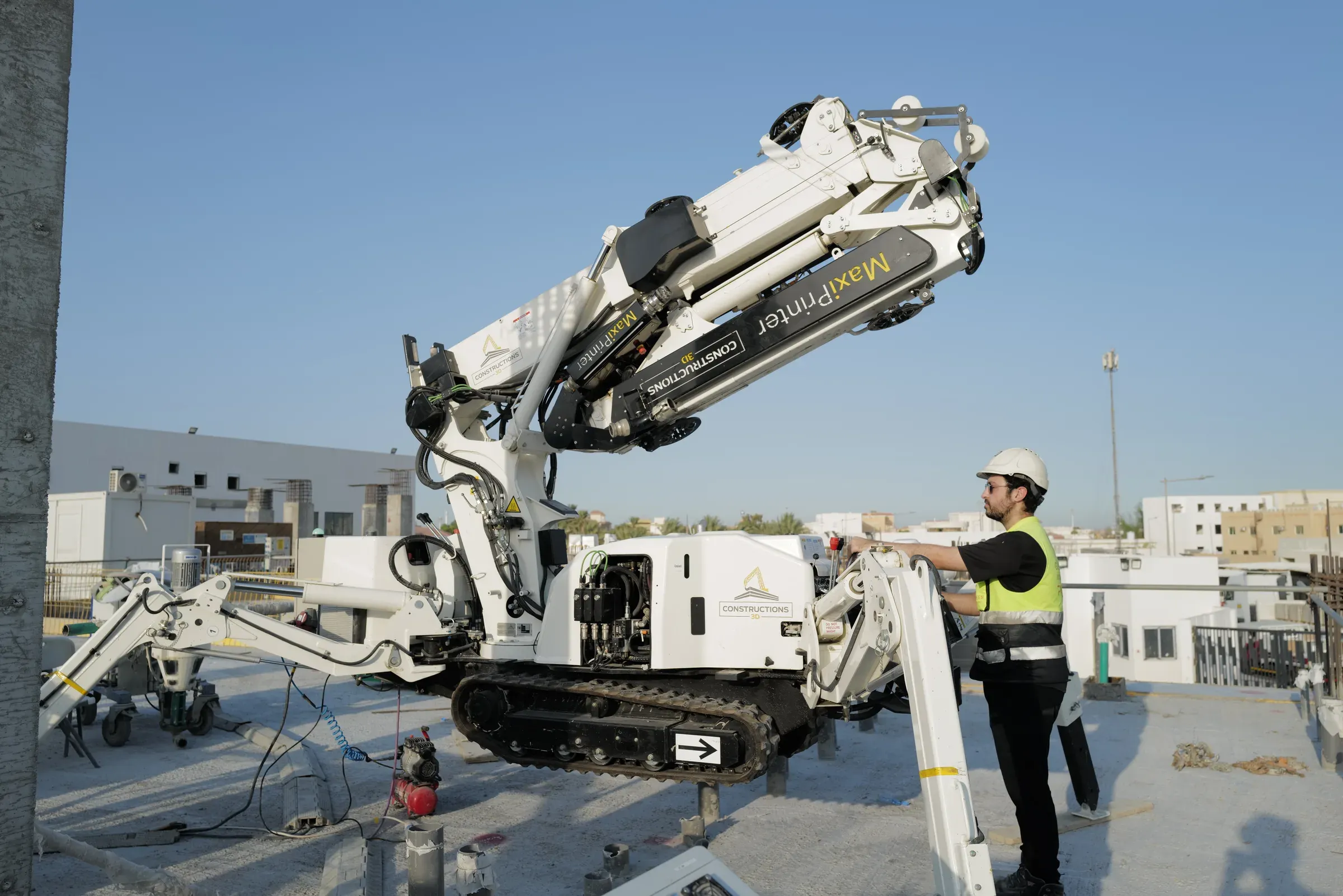 A GGI operator setting up a printer on the roof slab at School 08, Doha