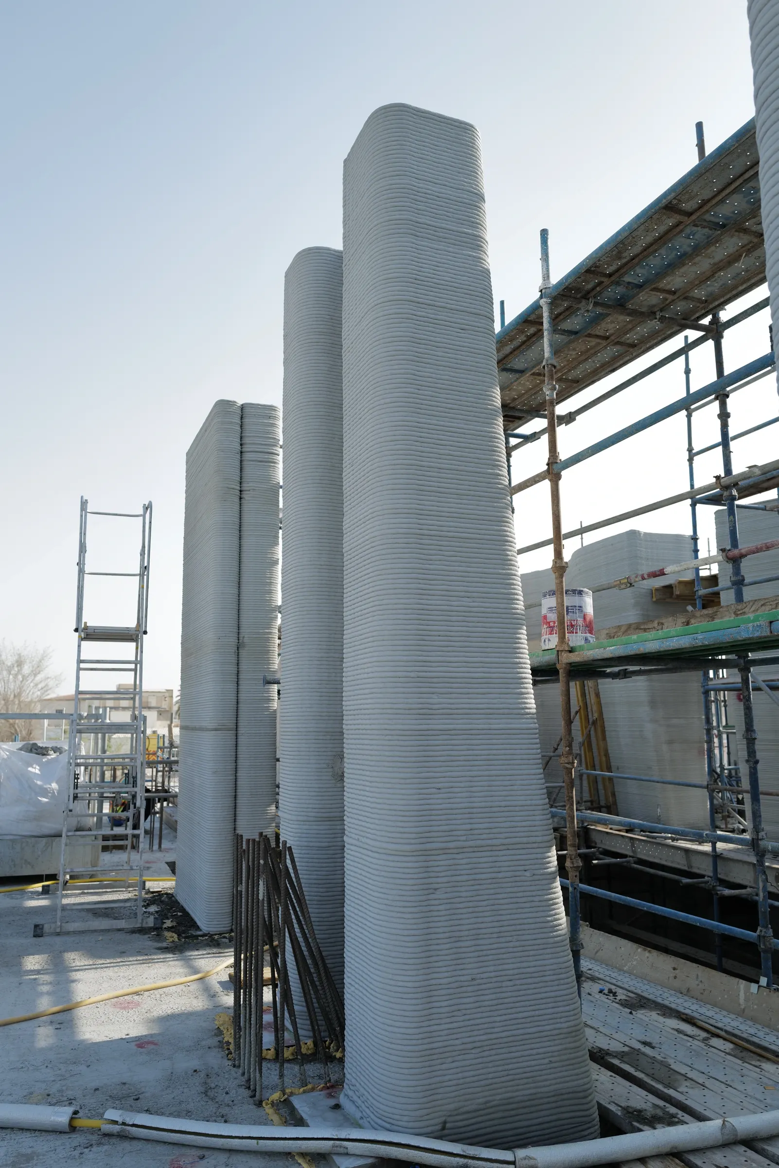 A row of tapered printed columns beside the scaffold at School 08