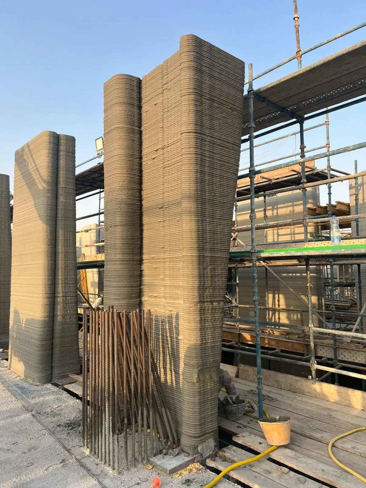 Printed columns and wall ends at School 08, with reinforcing bars standing ready beside them