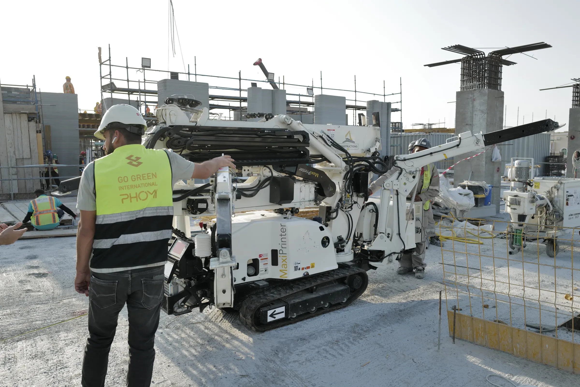 A GGI printer operator beside a 3D printer at School 08, Doha
