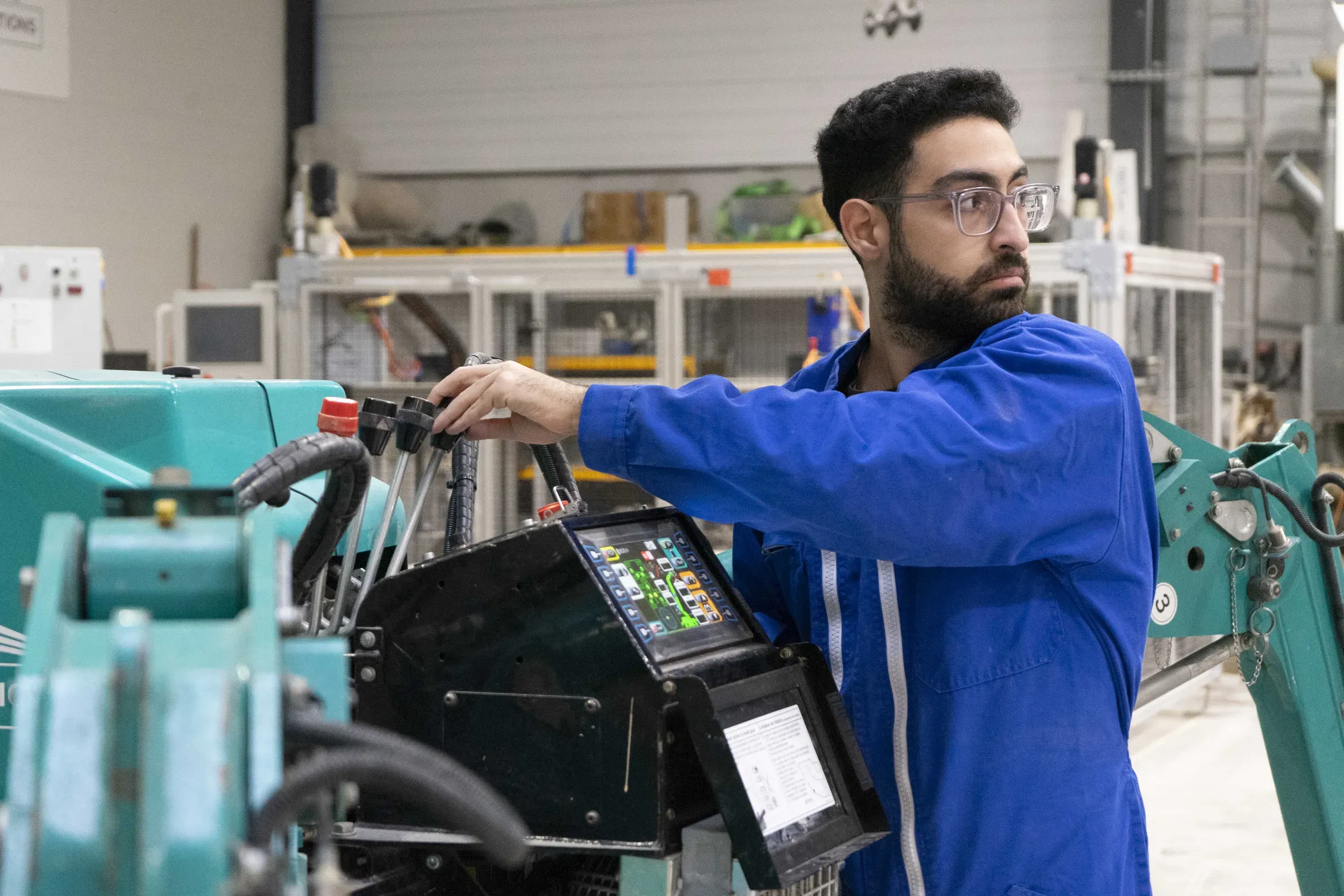 A GGI team member at the printer control panel in a workshop